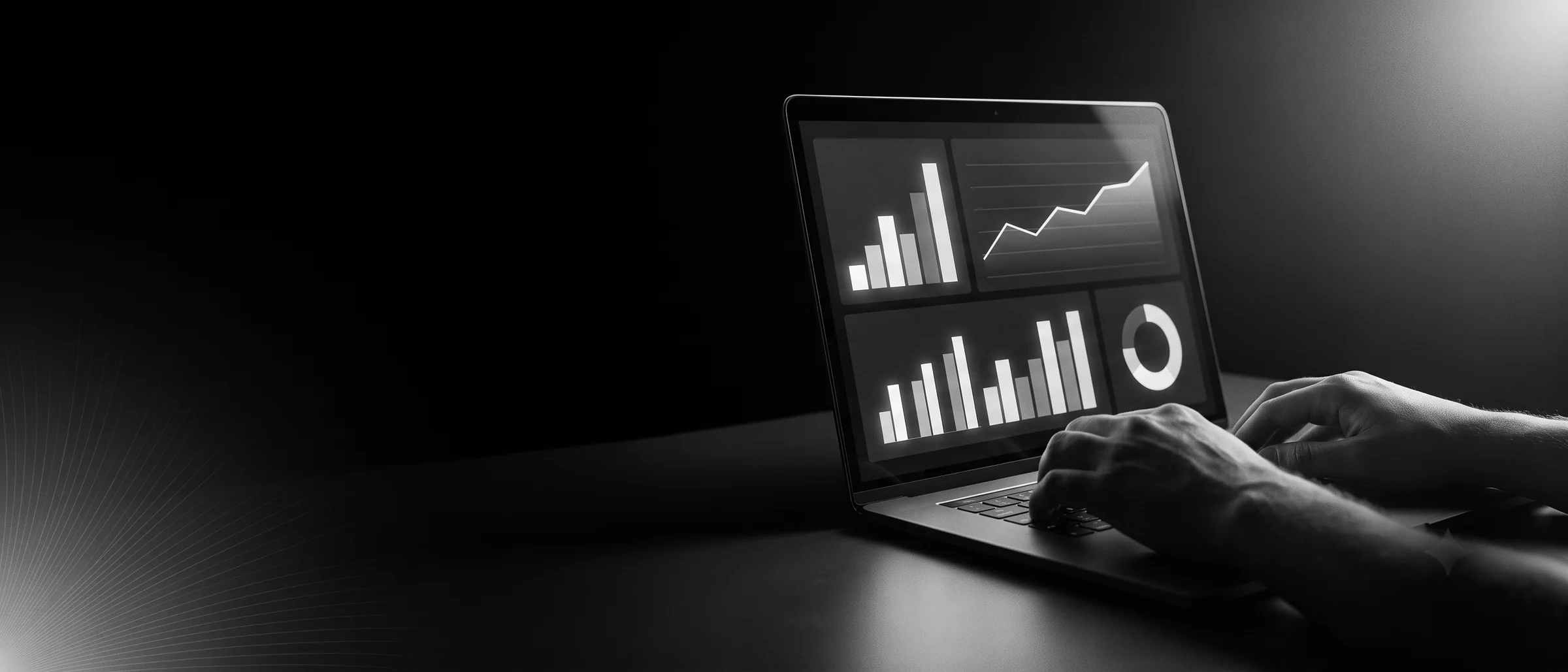 Laptop en una sala a oscuras mostrando un tablero de analitica; la pantalla es la unica fuente de luz.