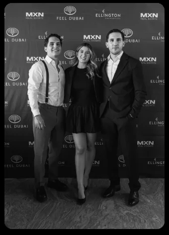 Alexis Abascal with two attendees in front of the MXN Real Estate, Feel Dubai and Ellington Properties backdrop.