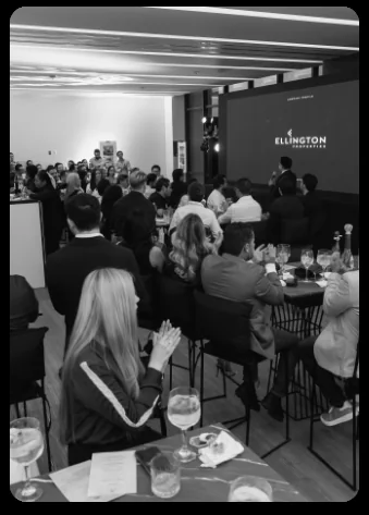 Attendees applauding at one of the event tables.